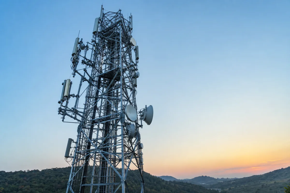Pylône relais couvert d&rsquo;antennes se détachant sur un ciel dégagé en fin de journée