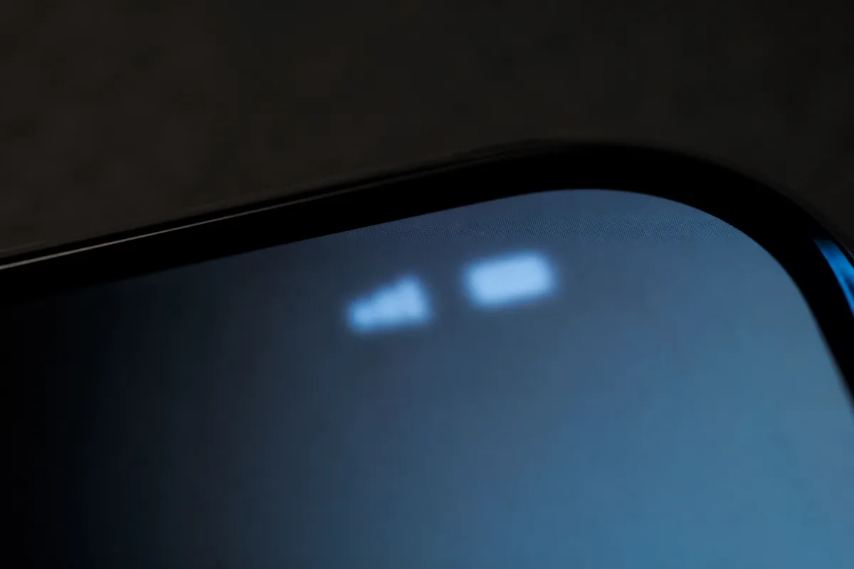 Deux indicateurs de réseau côte à côte en haut d’un écran de téléphone, cadrage macro très rapproché, image volontairement floue