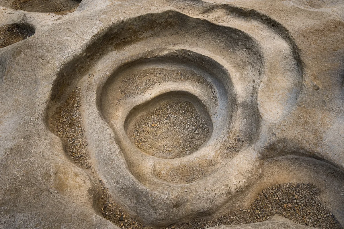 Escalier de pierre en colimaçon vu du dessus dans une tour aux murs nus